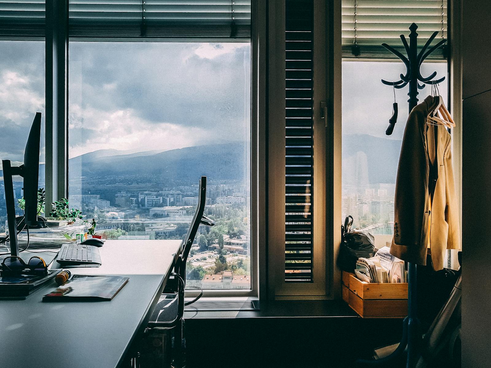 A contemporary office setting with a stunning mountain view through large windows and stylish furnishings.