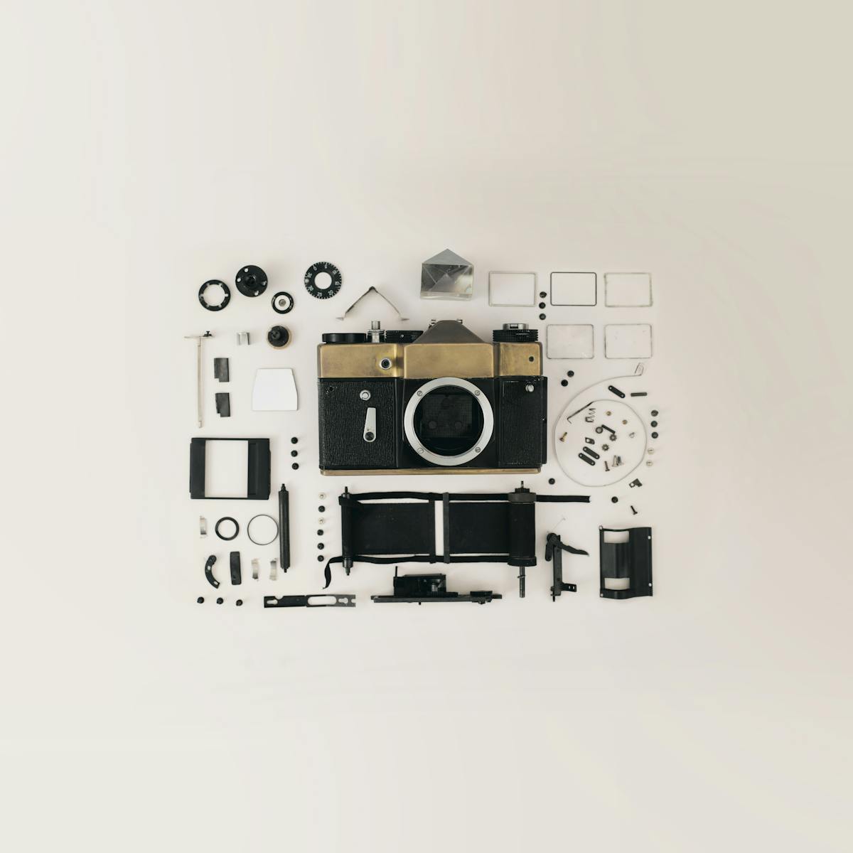 Flat lay of disassembled vintage camera parts showcasing intricate components and design.