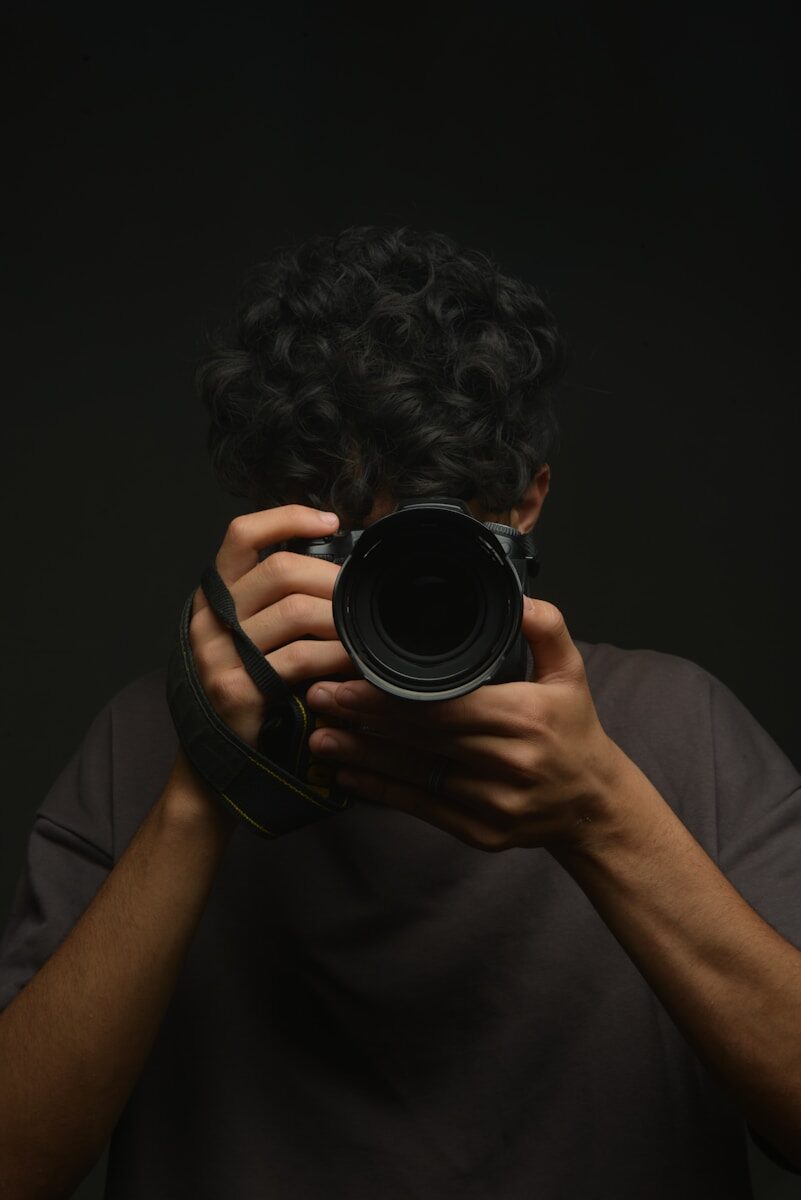 A man holding a camera up to his face