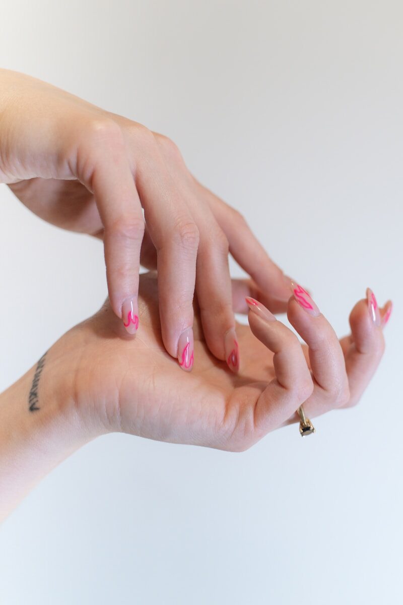 a woman's hands with pink and white manicures